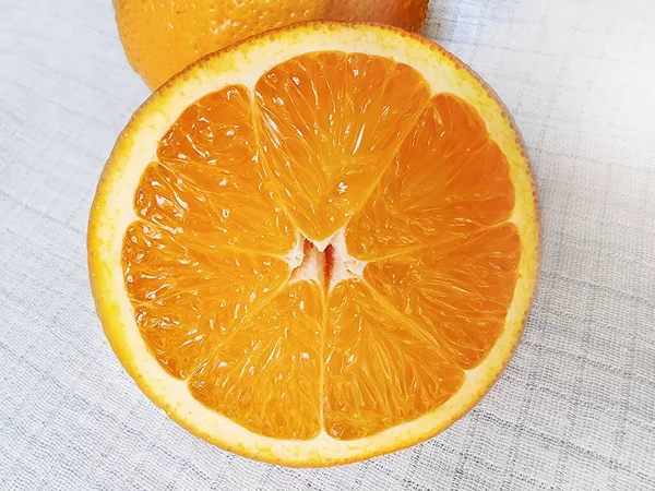 Zwei Ungleichmäßige Saftige Orangen Auf Einer Weißen Leinentischdecke Nahaufnahme — Stockfoto
