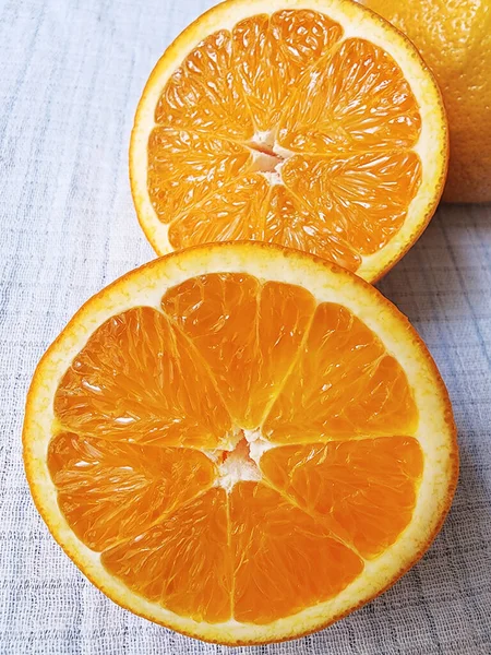 Eine Hälfte Saftige Orange Auf Einem Weißen Leinentischtuch Nahaufnahme Makro — Stockfoto