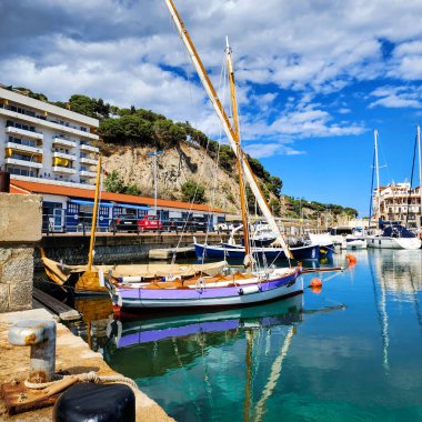 Marinaya demirlemiş yelkenli ve yatlar. Arka planda yat ve liman olan deniz manzarası. Arenys de Mar. Katalonya. İspanya.