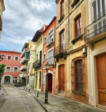 Eski şehrin dar sokakları. Kapıları ve balkonları olan güzel renkli yüzler. Arenys de Mar. Katalonya. İspanya.
