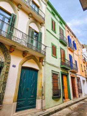 Eski şehrin dar sokakları. Kapıları ve balkonları olan güzel renkli yüzler. Arenys de Mar. Katalonya. İspanya.