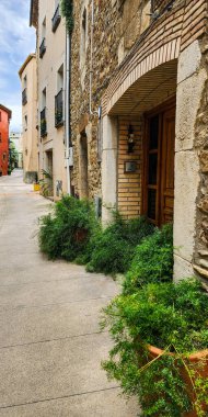 Eski şehrin dar sokakları. Ön cephelerdeki eski taş kapılar ve balkonlar. Şehir manzarası. Katalonya. İspanya.