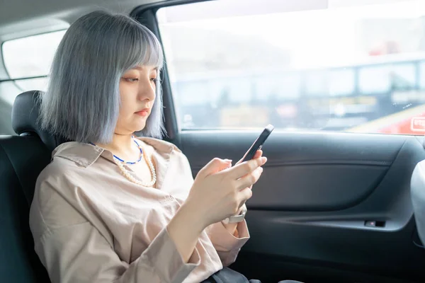 대만의한 여자가 스마트폰을 택시를 내다보고 — 스톡 사진