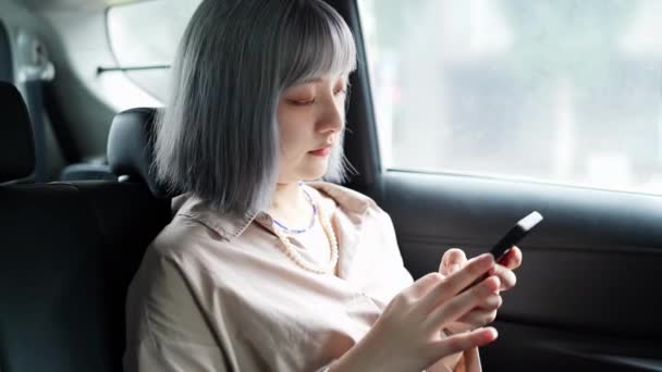 Una Joven Taiwanesa Operando Teléfono Inteligente Mirando Afuera Taxi Conduciendo — Vídeo de stock