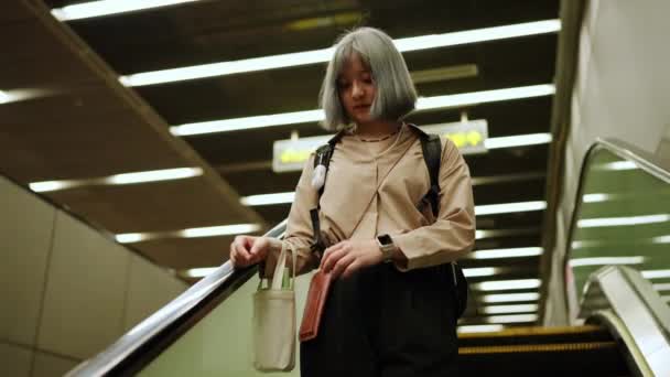 台湾台北 一名妇女拿着智能手机穿过地铁站 — 图库视频影像