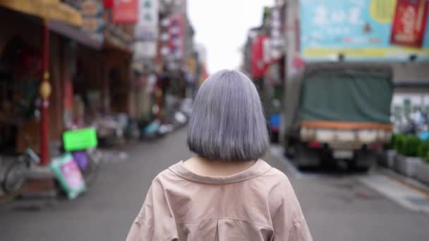 ジョア ストリートの古い通りを散策する灰色の髪の若い台湾人女性のスローモーションビデオ — ストック動画