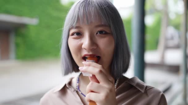 Seorang Wanita Taiwan Muda Makan Permen Sebuah Bangunan Artistik Taman — Stok Video