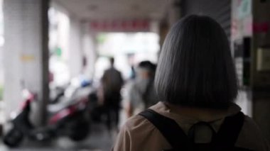 Tayvanlı genç bir kadın Taipei sokaklarında yürüyor.