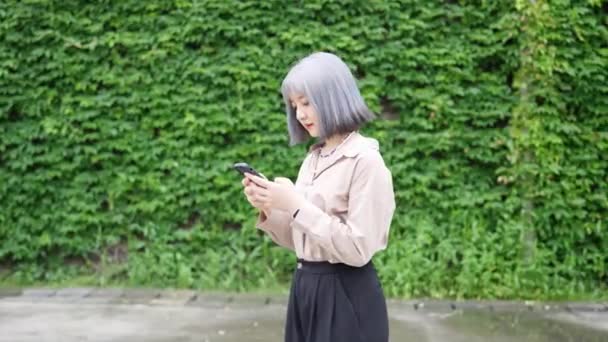 台湾华山1914年文化创意公园 台湾一名年轻女子在一幢艺术大楼里操作智能手机 — 图库视频影像