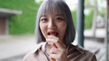 Tayvanlı genç bir kadın Taipei 'deki Huashan 1914 Kültür ve Yaratıcı Park' taki bir sanat binasında Japon wagashi yokanı (tatlı fasulye jölesi) yiyor..
