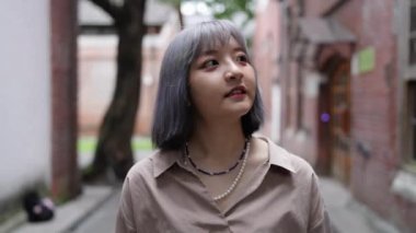 Tayvanlı genç bir kadın, Taipei 'deki Huashan 1914 Kültür ve Yaratıcı Parkı' nda sanatsal bir binada yürüyor..