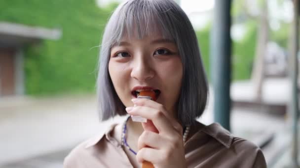 台湾の若い女性は 台北のHuashan1914文化クリエイティブパークの芸術的な建物で日本のワゴシのヨギを食べます — ストック動画