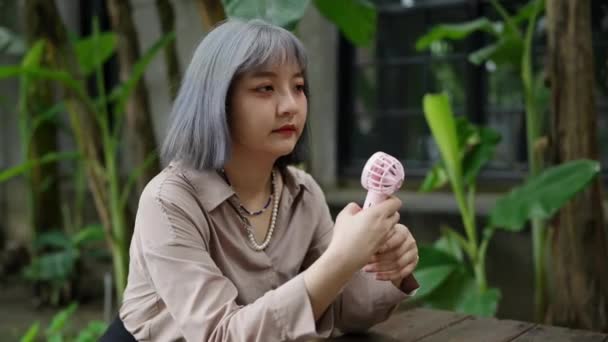 Seorang Wanita Muda Taiwan Duduk Dan Dingin Dengan Seorang Penggemar — Stok Video