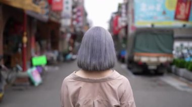  Genç bir Tayvanlı kadın geleneksel Taipei mahallesi Dihua Caddesi 'nde yürüyor..