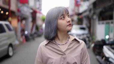  Genç bir Tayvanlı kadın geleneksel Taipei mahallesi Dihua Caddesi 'nde yürüyor..