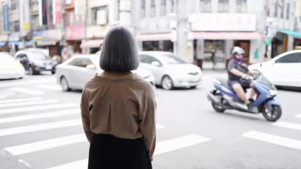 台湾の若い女性が 伝統的な台北市街の交差点に立っている — ストック動画