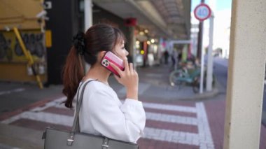 Japonya 'nın Aichi ilindeki Nagoya şehrindeki Osu alışveriş bölgesi yakınlarında akıllı telefonuyla konuşan genç bir Japon kadın..