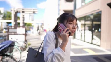 Japonya 'nın Aichi ilindeki Nagoya şehrindeki Osu alışveriş bölgesi yakınlarında akıllı telefonuyla konuşan genç bir Japon kadın..