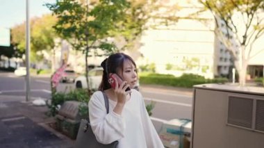 Japonya 'nın Aichi ilindeki Nagoya şehrindeki Osu alışveriş bölgesi yakınlarında akıllı telefonuyla konuşan genç bir Japon kadın..