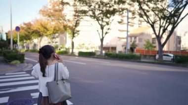 Japonya 'nın Aichi ilindeki Nagoya şehrindeki Osu alışveriş bölgesi yakınlarında akıllı telefonuyla konuşan genç bir Japon kadın..