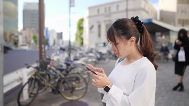 Молода Японка Керує Смартфоном Вздовж Дороги Біля Торгового Району Осу — стокове відео