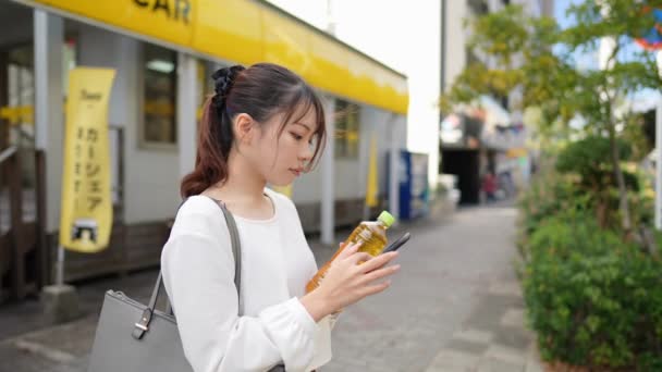 Mladá Japonská Žena Provozující Smartphone Podél Silnice Poblíž Nákupní Čtvrti — Stock video