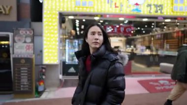 30 'lu yaşlarında Güney Koreli bir adam kışın Myeongdong, Seul, Güney Kore' de kar yağışı altında etrafı geziyor..