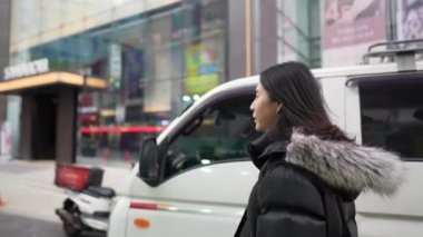 30 'lu yaşlarında Güney Koreli bir adam kışın Myeongdong, Seul, Güney Kore' de kar yağışı altında etrafı geziyor..