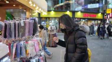 30 'lu yaşlarında Güney Koreli bir adam kışın Myeongdong, Seul, Güney Kore' de kar yağışı altında etrafı geziyor..