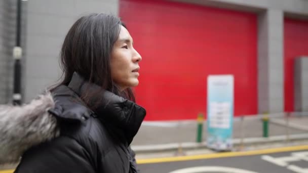 在韩国首尔绵东市的一条街上 一个30多岁 留着长发的韩国男子在冬雪中观光 — 图库视频影像