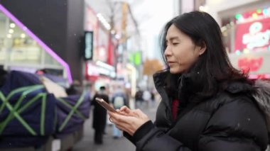 30 'lu yaşlarında Güney Koreli bir adam kışın Myeongdong, Seul, Güney Kore' de kar yağışı altında etrafı geziyor..