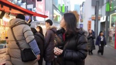 30 'lu yaşlarında Güney Koreli bir adam kışın kar yağarken Myeongdong, Seul, Güney Kore' de bir sokakta gece gezintisi yapıyor..