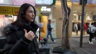 30 'lu yaşlarında Güney Koreli bir adam kışın kar yağarken Myeongdong, Seul, Güney Kore' de bir sokakta gece gezintisi yapıyor..