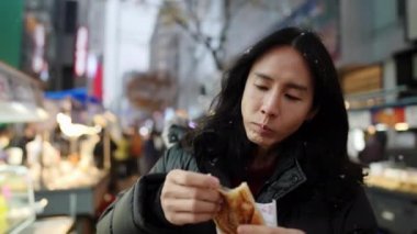 30 'lu yaşlarında Güney Koreli bir adam kışın kar yağarken Myeongdong, Seul, Güney Kore' de bir sokakta gece gezintisi yapıyor..