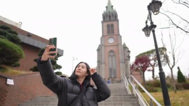 30 'lu yaşlarında uzun saçlı bir Koreli Myeong-dong, Seul, Güney Kore' de bir kilisede yürüyüş yapıyor.