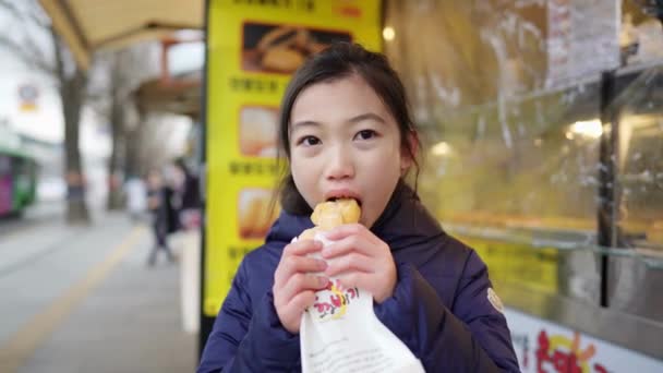 Vídeo Câmera Lenta Uma Garota Coreana Comprando Comendo Pão Frito — Vídeo de Stock