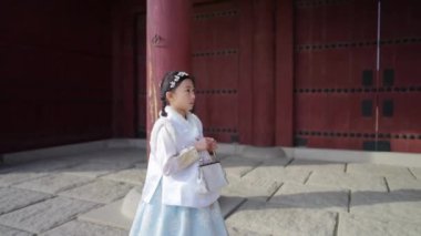 Güney Kore, Seul 'deki Gyeongbokgung Sarayı' nda Chimachogori giyen Koreli bir kızın yavaş çekim videosu.
