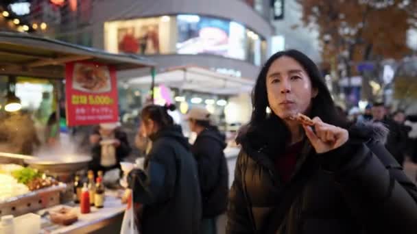 Długowłosy Koreańczyk Trzydziestce Który Kupuje Przekąski Nocnym Targu Śnieżną Zimną — Wideo stockowe