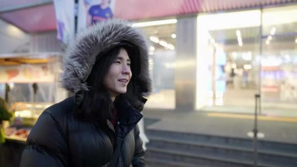 Długowłosy Koreańczyk Trzydziestce Kapturze Spacerujący Nocnym Targu Śnieżną Zimną Noc — Wideo stockowe