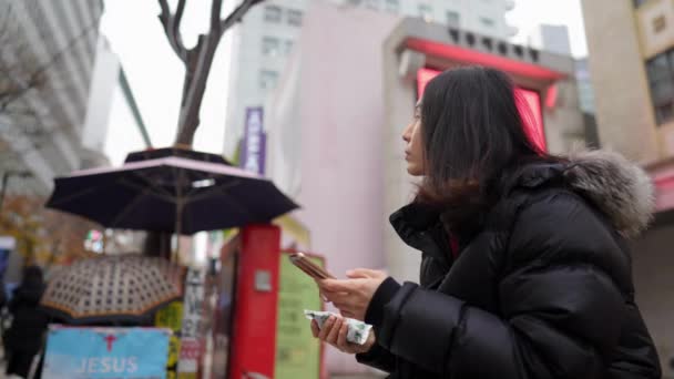 Filmik Długowłosym Koreańczykiem Trzydziestce Operującym Smartfonem Mroźnej Zimie Myeong Dong — Wideo stockowe