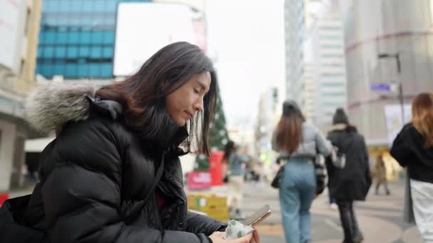 30대 남성의 슬로우 비디오 서울특별시 명동의 겨울에 스마트폰을 운영하는 30대 — 비디오