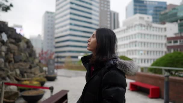 30代の長髪の韓国人男性のスローモーションビデオは 韓国ソウル 明洞の寒い冬の教会で女神像に祈っています — ストック動画