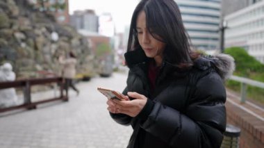 Myeong-dong, Seul, Güney Kore 'de soğuk bir kış günü kilisede tanrıça heykeline dua eden 30' lu yaşlarında uzun saçlı Koreli bir adamın yavaş çekim videosu.