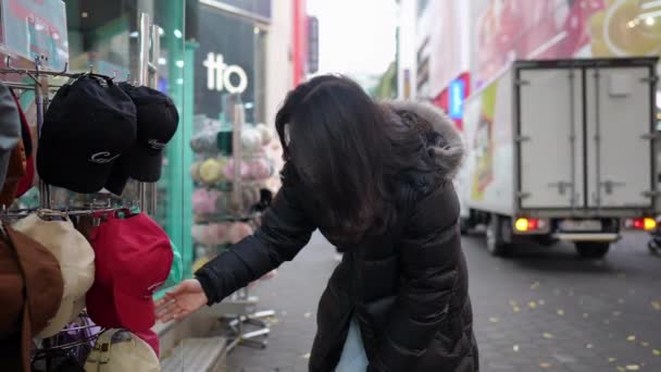 韩国首尔明东寒冷的冬季 一个30多岁的韩国男人在大街上购物时的慢镜头 — 图库视频影像