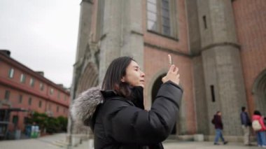  Myeong-dong, Seul, Güney Kore 'de soğuk bir kış günü kiliseyi ziyaret eden 30' lu yaşlarında uzun saçlı Koreli bir adamın yavaş çekim videosu.