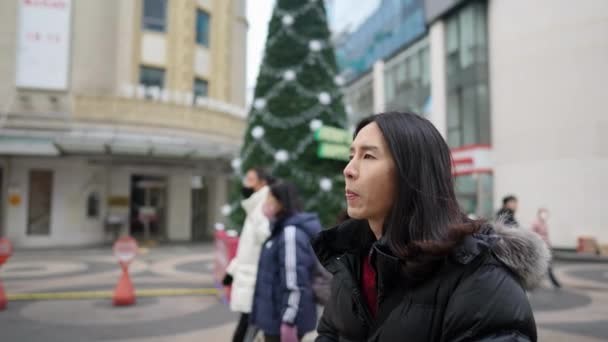 30대 남자의 슬로우 비디오 서울특별시 명동에서 겨울에 크리스마스 앞에서 스마트폰으로 — 비디오