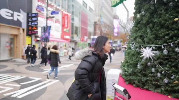 30대 남자의 슬로우 비디오 서울특별시 명동에서 겨울에 크리스마스 앞에서 스마트폰으로 — 비디오