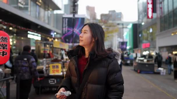 30代の韓国人男性のスローモーションビデオ ソウル 韓国の寒い冬の夜に夜市を散策 — ストック動画