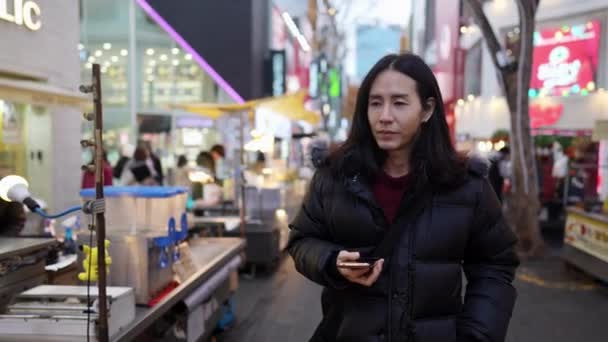 30代の韓国人男性のスローモーションビデオ ソウル 韓国の寒い冬の夜に夜市を散策 — ストック動画