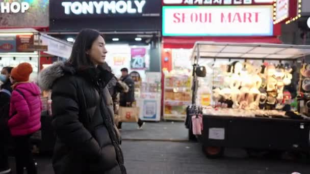 韩国首尔明东 一个寒冷的冬夜 一个30多岁的韩国男子在夜市漫步的慢镜头 — 图库视频影像